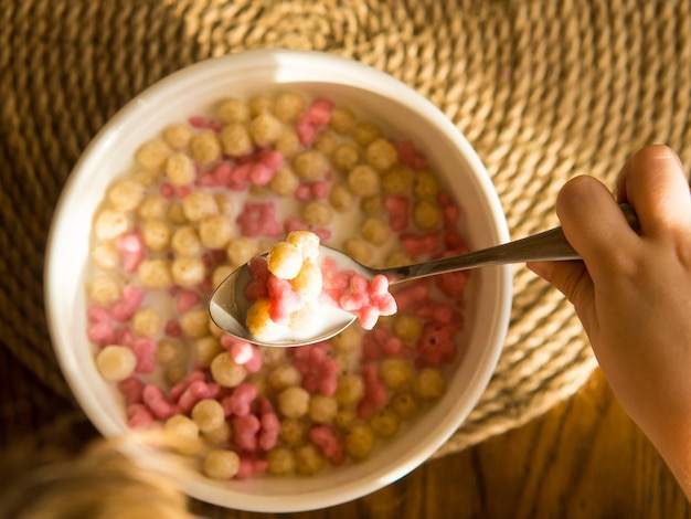 child having breakfast with corn flakes and milk