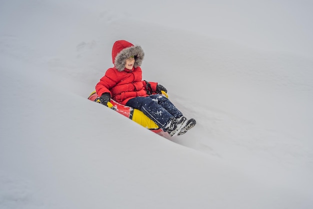 Child having fun on snow tube boy is riding a tubing winter fun for children