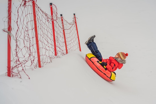 Child having fun on snow tube Boy is riding a tubing Winter fun for children