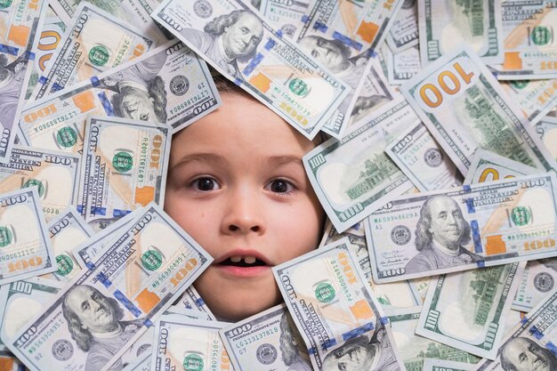 Child head in money money banknotes cash dollars bills fun kid face on dollars money shopping and fi