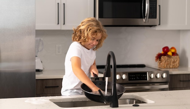 Child help in washing dishes at kitchen cleaning dishwashing during housework