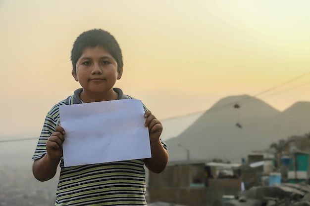 Child holding a blank sheet of paper to insert positive or motivational text or message.