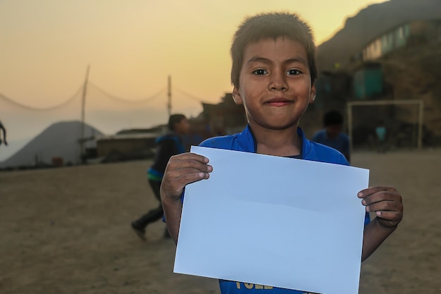 Child holding a blank sheet of paper to insert positive or motivational text or message.