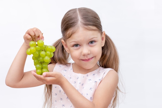 Child holding bunch of grapes