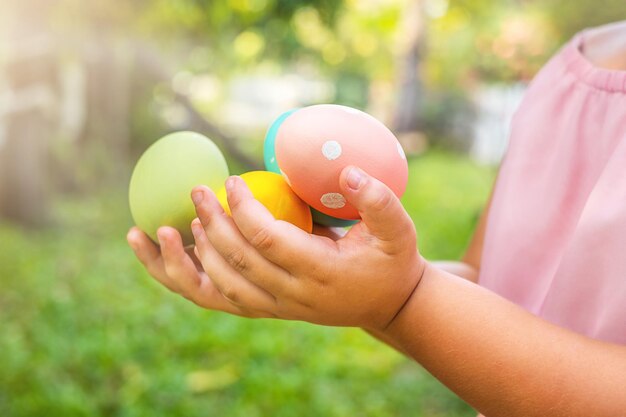 Child holding Easter eggs in the backyard