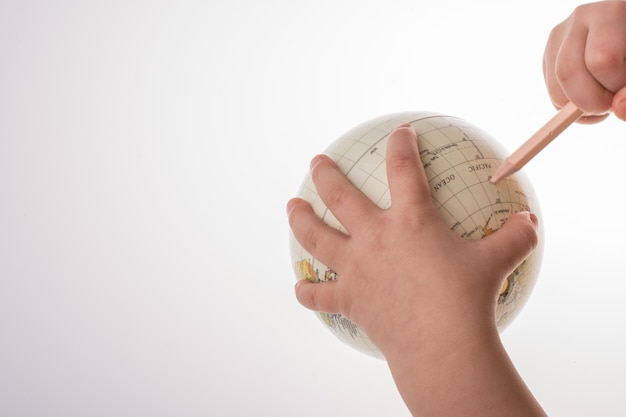 Child holding a globe and a pen in his hand