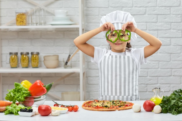 The child holding green bell peppers