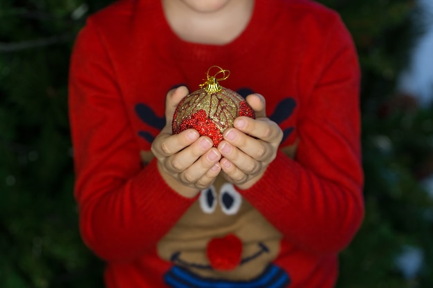 Child holding one Christmas decoration ball