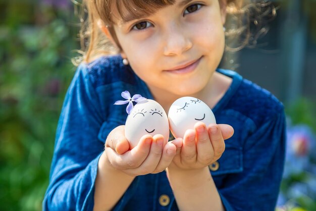 The child holds Easter eggs in his hands. Selective focus.