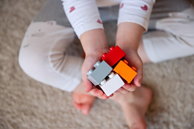 Child holds in the palms of the blocks Kid hands with bricks toy