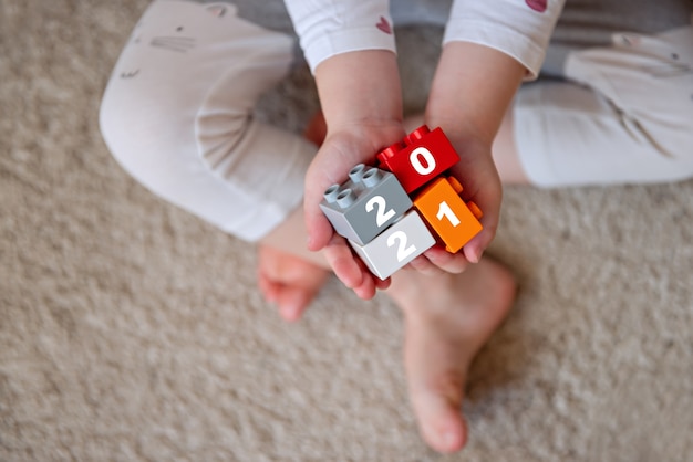 Child holds in the palms of the blocks Kid hands with bricks toy