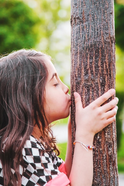 A child hugs a tree loves and protects nature Selective focus