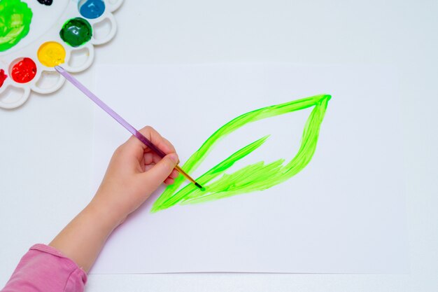 Child is drawing green leaf