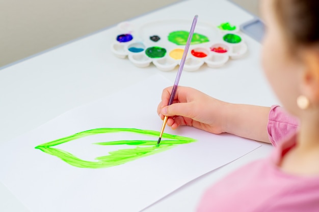 Child is drawing green leaf