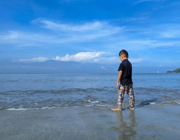 A child is enjoying playing in the sea water on the beach