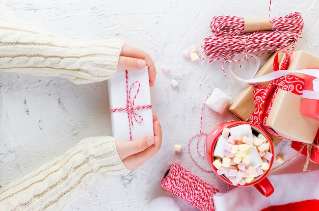 Child is holding Christmas gift box with a red ribbon