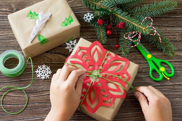 A child is holding Packing presents for Christmas Handmade Project of childrens creativity