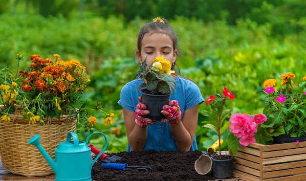 The child is planting flowers in the garden Selective focus