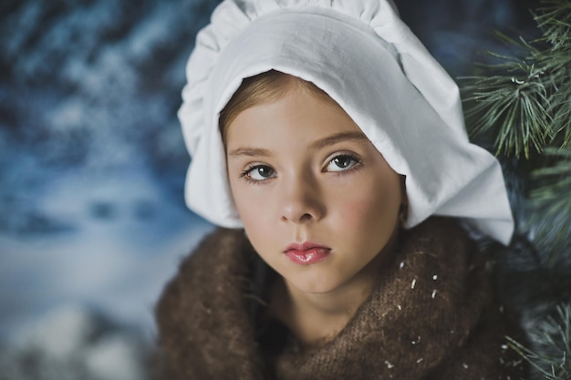 The child is sitting pensively in the winter forest 4833