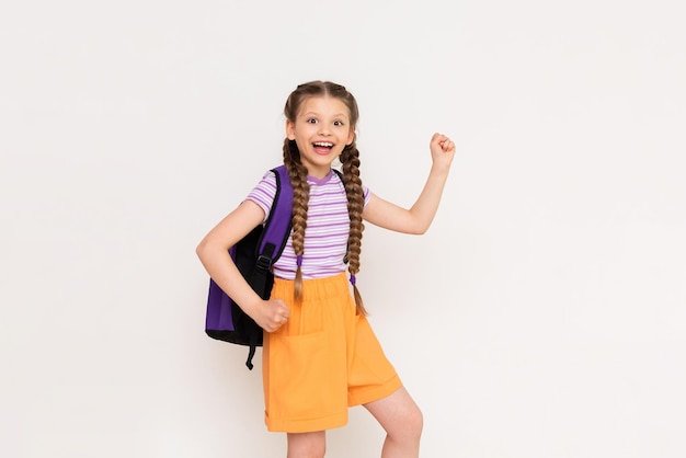 The child is very happy about the summer educational courses for children A beautiful little girl holds up her fists and smiles broadly on a white isolated background