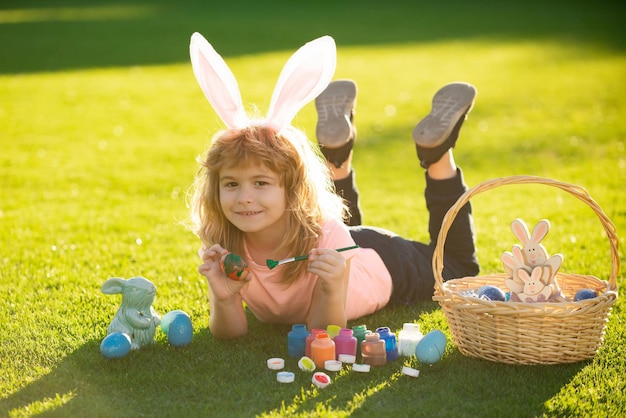 Child laying on grass in park wit easter eggs cute kid having happy easter in park