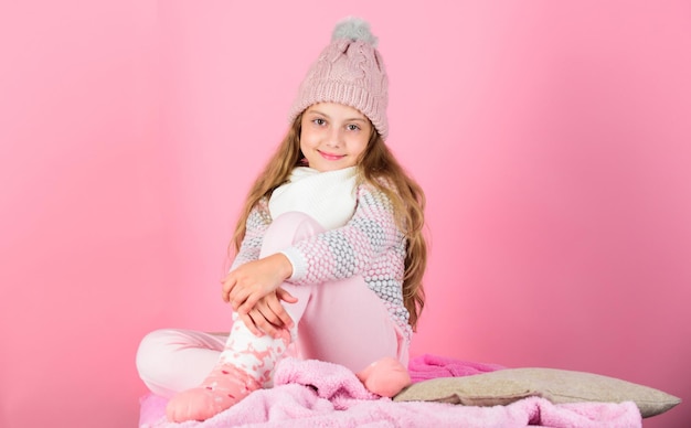 Photo child long hair warm woolen hat enjoy warm warm clothes concept keep warm and comfortable warm accessories that will keep you cozy this winter kid girl wear knitted hat relaxing pink background