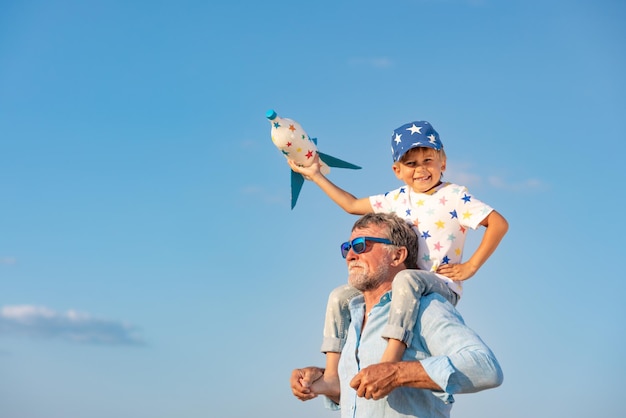 Child looking through spyglass against blue sky. Kid having fun outdoor in summer. Adventure and travel concept