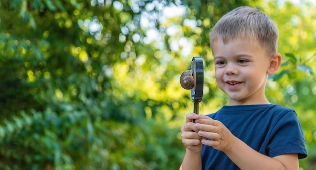 The child looks at the snail nature Selective focus