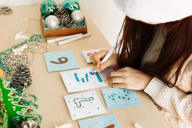 a child makes a Christmas advent calendar out of paper with his own hands diy close up