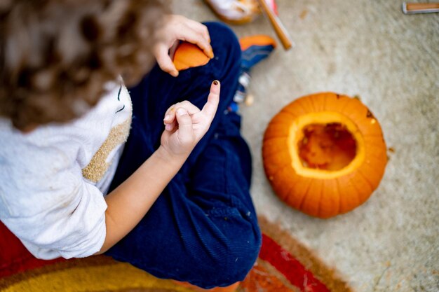 child makes pumpkin for halloween