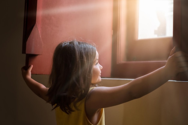 The child opens the window shutters