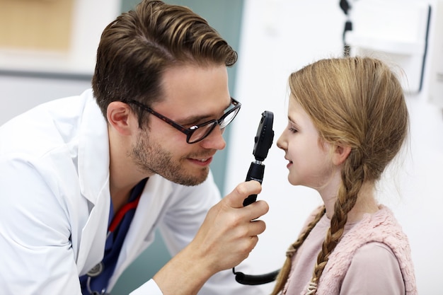 child optometry male optometrist optician doctor examines eyesight of little girl