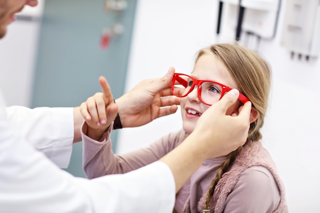 child optometry male optometrist optician doctor examines eyesight of little girl