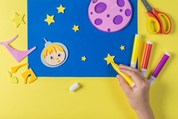 A child paints a star on paper applications on the theme of space