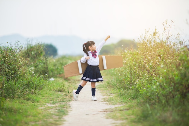 Child pilot aviator with airplane dreams of traveling in summer in nature at sunset