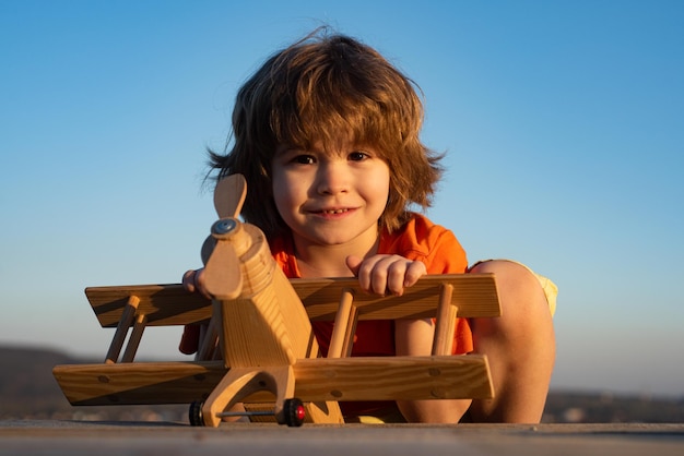 Child pilot aviator with kids airplane dreams of traveling in summer in nature