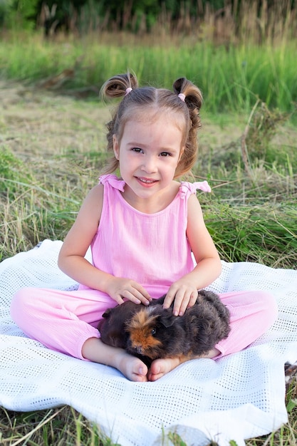 Child playing with guinea pig Kids feed cavy animals Little girl holding and feeding domestic animal Children take care of pets Preschooler kid petting hamster Pet rodents Trip to zoo or farm