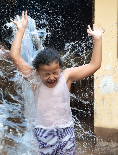 Child playing in the yard with water in the Brazilian summer