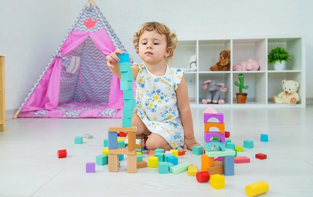 The child plays in the children's room with a wooden constructor Selective focus