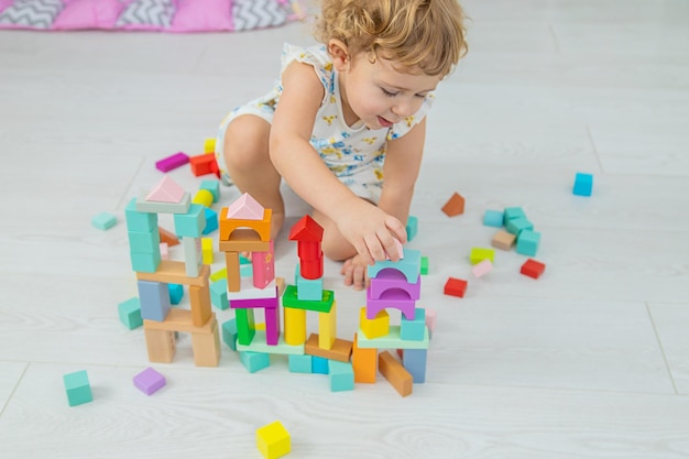 The child plays in the children's room with a wooden constructor Selective focus