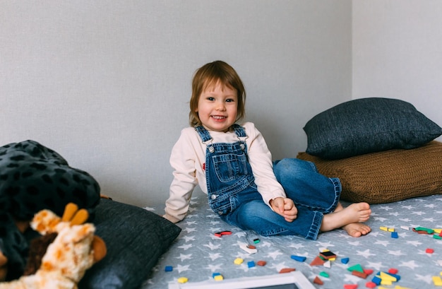 Child plays at home an educational game with a multicolored magnetic puzzle