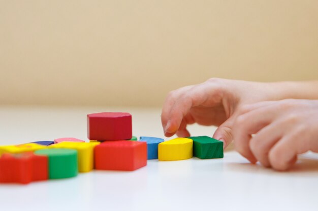 The child plays with colored figures. Details of the toy in the hands.