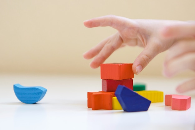 The child plays with colored figures. Details of the toy in the hands.