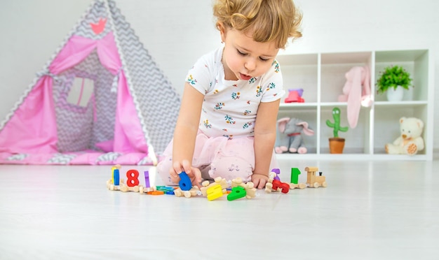 A child plays with a train made of numbers Selective focus