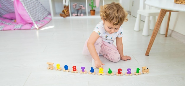 A child plays with a train made of numbers Selective focus