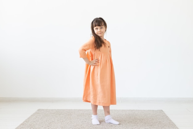 Child posing in a orange dress