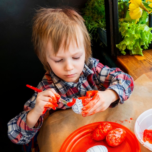 The child preparing for Easter Paint eggs Red paint egg