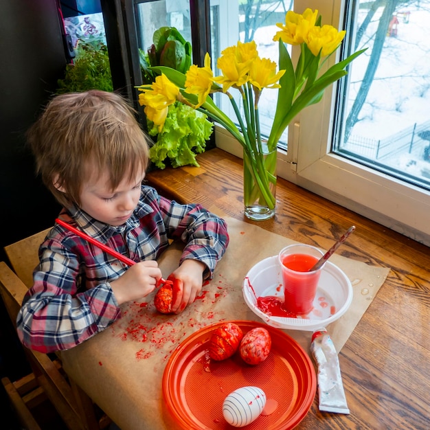 The child preparing for Easter Paint eggs Red paint egg