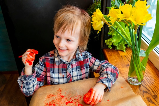 The child preparing for Easter Paint eggs Red paint egg