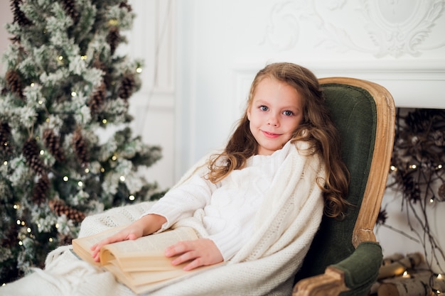 Child reading book at home on Christmas